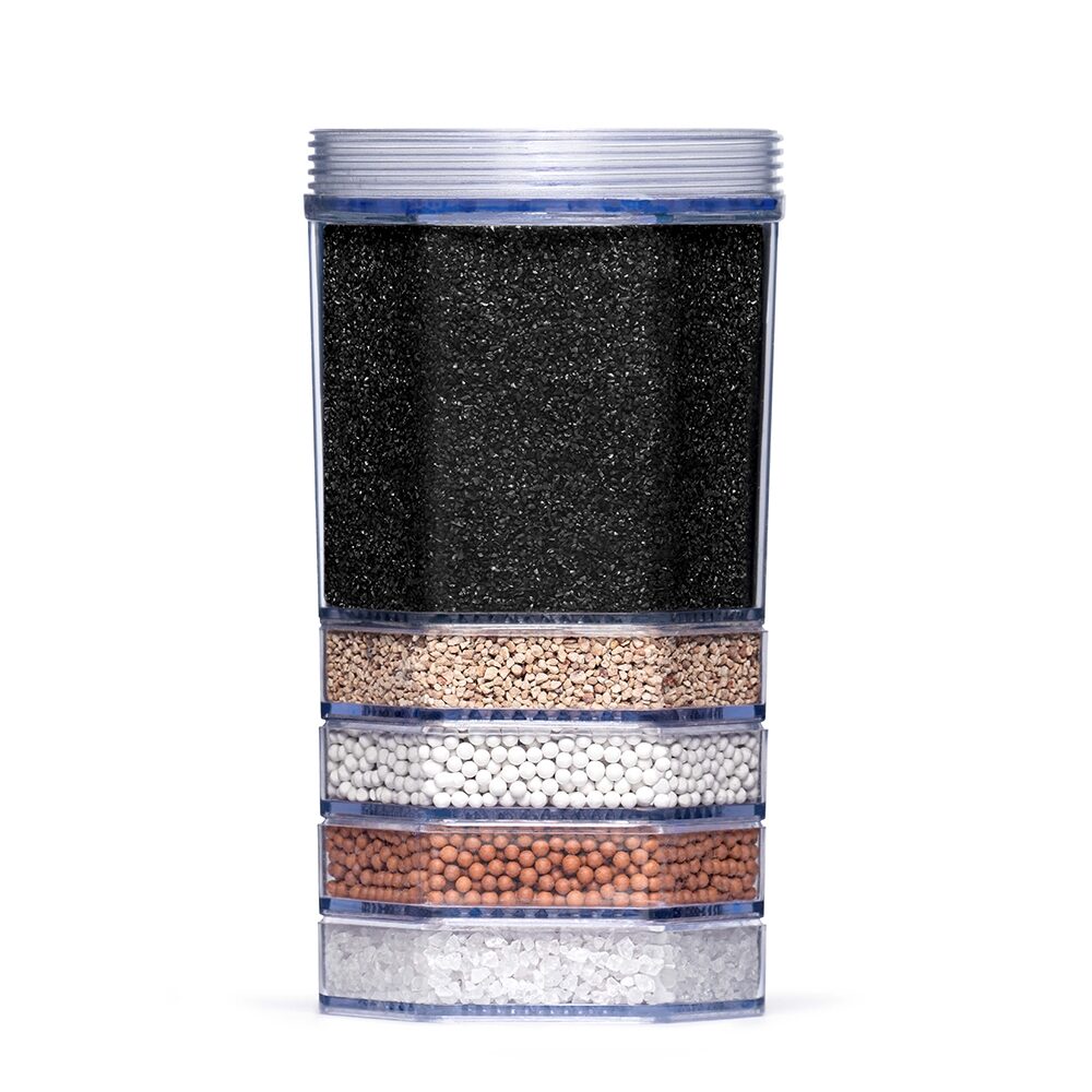 Eine transparente Wasserfilter-Kartusche im Querschnitt, die fünf verschiedene Schichten von Filtermedien wie Aktivkohle und Mineralien zeigt.