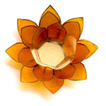 Ein orangefarbener Teelichthalter in Form einer Lotusblüte mit goldenem Rand, von oben fotografiert auf weißem Hintergrund.
