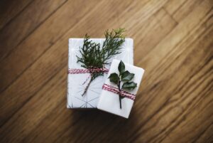Zwei liebevoll verpackte Weihnachtsgeschenke, mit Naturzweigen dekoriert, symbolisieren nachhaltige und herzliche Geschenkideen.